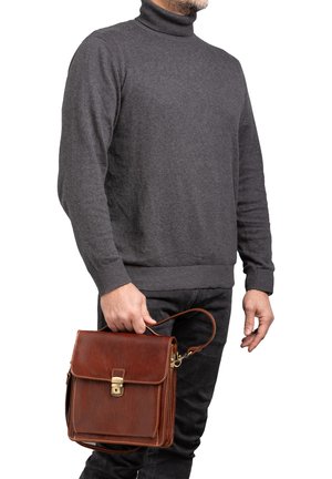 Borsa a tracolla in pelle marrone con chiusura a pattina, accessori in ottone e dettagli di cucitura. La borsa è dotata di una tracolla.