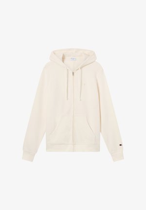 Sudadera con capucha color crema con cremallera, bolsillos delanteros, cordones en la capucha y un pequeño logo de Champion en el puño de la manga izquierda.