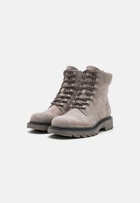 Bocanci scurti din suede gri, cu talpă din cauciuc, având șireturi decorative, accente metalice și o guleră căptușită pentru confort.