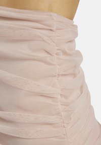 Weiches, hellrosa gerafftes Material mit zarter Textur; hebt die Nahtdetails und das fließende Design hervor. Geeignet für Schichten- oder figurbetonte Styles.