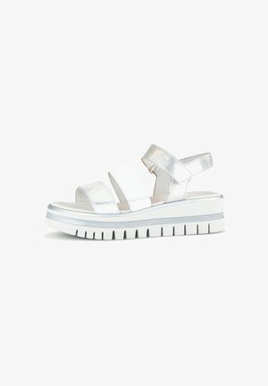 White sandal with metallic silver accents. Features wide straps and a thick, ridged platform sole. Smooth texture and open toe design.