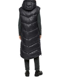 Langer schwarzer Puffer-Westen mit Kapuze, der ein Zickzack-gestepptes Muster aufweist. Auffällige glänzende Textur, die unter die Knie reicht.
