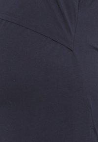 Tecido azul-marinho com uma textura suave, apresentando um design de costura diagonal. O material parece leve e ligeiramente elástico.