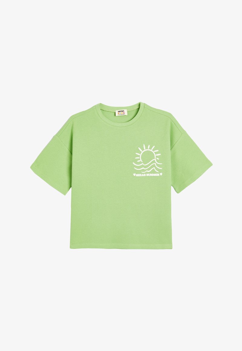 Lysegrøn kortærmet t-shirt lavet af tekstureret stof, der har et hvidt sol- og bølgedesign på fronten. Boksformet design.