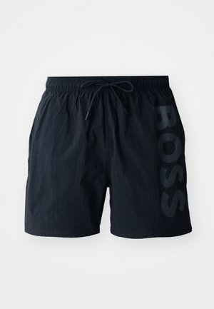 Shorts de bain noirs en tissu léger, dotés d'une taille élastique avec cordon de serrage et d'un grand logo "BOSS" imprimé en foncé sur le côté.