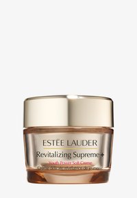 Klare Glasdose mit goldenem Deckel, die eine Creme mit der Aufschrift "Revitalizing Supreme+" und "Youth Power Soft Crème" in schwarzem und pinkem Text enthält.