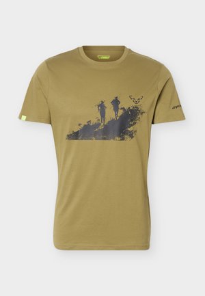 T-shirt kaki à manches courtes avec un graphisme noir représentant deux coureurs de trail sur un chemin accidenté et un petit logo animal sur la poitrine.