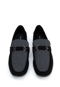 Mocassins en daim noir avec un dessus en tissu pied-de-poule gris, avec des accents en métal argenté et un design à bout rond.