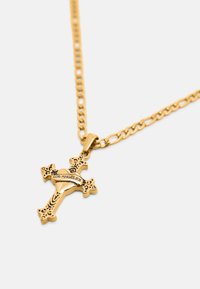 Kuldne kettkaelakee dekoratiivse ristkujuga ripatsiga, millel on süda ja "LOS ANGELES" kirje tavalise tausta ees.