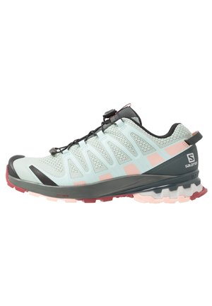 Hellblauer und rosafarbener Salomon Trailrunning-Schuh mit schwarzen und roten Akzenten, Mesh-Obermaterial und robuster Sohle, seitlich gezeigt.