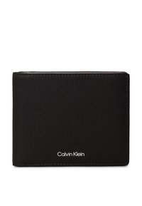Portefeuille bifold noir en cuir lisse avec des coutures visibles. Présente un logo "Calvin Klein" blanc en bas à l'avant. Design compact.