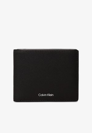 Črn bifold denarnica iz gladke usnjene kože z vidnimi šivi. Ima bel logotip "Calvin Klein" na sprednji strani. Kompaktna zasnova.
