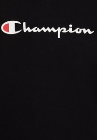 Black cotton T-shirt featuring a prominent white "Champion" logo, with a red accent in the letter "C," smooth texture and classic fit.