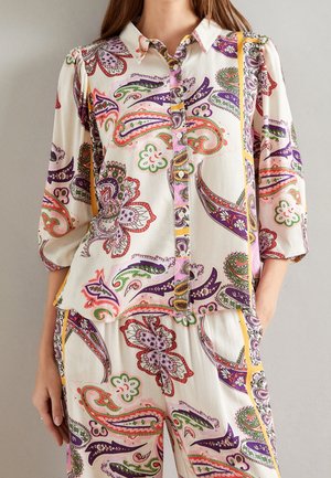 Witte blouse met een levendig paisleymotief in roze, groen en paars. Voorzien van een kraag, knoopsluiting aan de voorkant en driekwart mouwen.