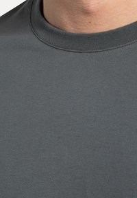 Mørk grå kortærmet t-shirt med rund hals, glat tekstur og fint ribbet detaljering omkring kraven.