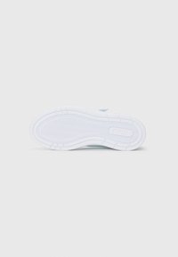 Semelle en caoutchouc blanc d'une sneaker avec un motif en chevron et la marque "Puma" visible sur la semelle.