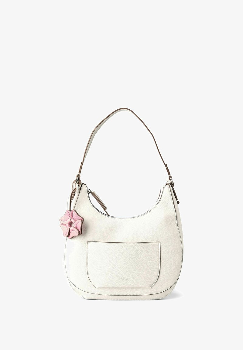 Borsa a tracolla bianca in pelle con tasca frontale e ciondolo a forma di fiore rosa appeso alla cinghia.