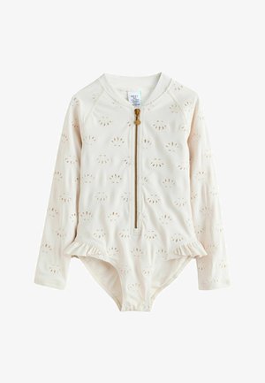 Dětské plavky s dlouhým rukávem v krémové barvě s vyšívanými motivy mušlí, předním zipem s přívěskem ve tvaru mušle a malými volánky na bocích.