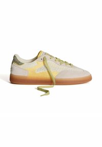 Zapatillas ligeras hechas de malla y ante, con un degradado en beige y amarillo, cordones verdes y una suela de goma.