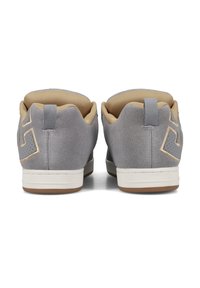 Hall grisist suede'i tossud, vaadatud tagant, beige sisevoodri, tõmblukukleepsude ja valgete vahevahetustega, pruuni välispinnaga.