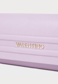 Μωβ δερμάτινη τσάντα clutch με χρυσό λογότυπο "VALENTINO" και υφή. Διαθέτει λεία επιφάνεια και εκλεπτυσμένο σχέδιο.