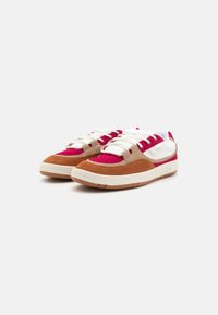 Sko i rød, brun og off-white ruskind, med en tekstureret gummisål, kontrastsnørebånd og polstret tunge.