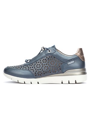 Zapatilla de cuero perforado azul con suela blanca y detalles metálicos. Cuenta con un diseño aerodinámico y punta redondeada. Cintas ajustables.