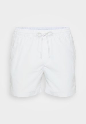 Weiße Badeshorts mit elastischem Bund, Kordelzug und seitlichen Taschen. Glatte Textur und Oberschenkel-lange Länge.