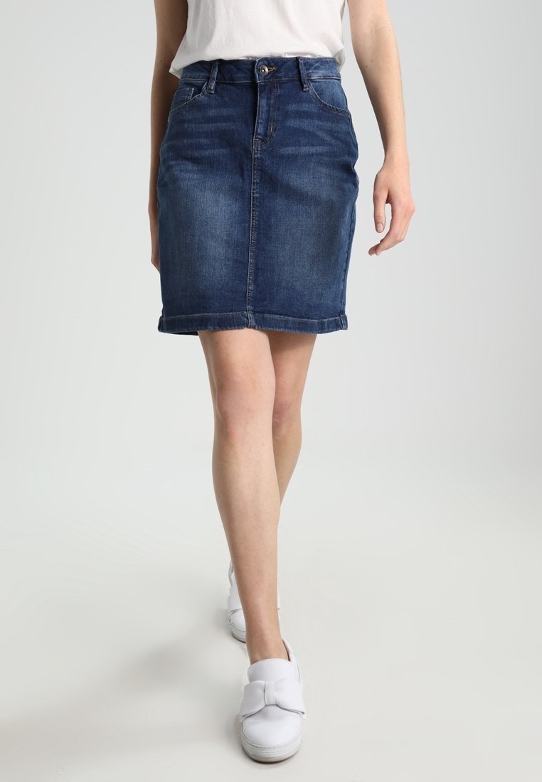 Džínová sukně v tmavě modré barvě, délky po kolena, s těsným střihem. Obsahuje zapínání na knoflík, poutka na opasek a lem s mírným třepením.