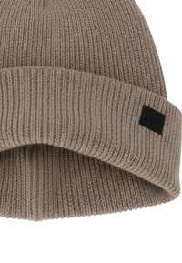 Beanie a coste di colore marrone chiaro con risvolto e piccolo logo nero rettangolare sul lato.