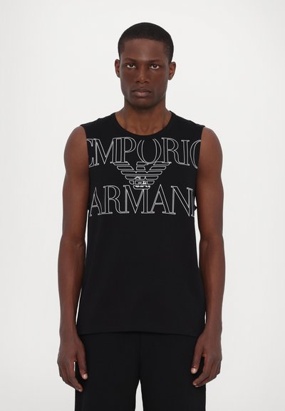 T-shirt en coton sans manches noir avec un grand logo blanc "Emporio Armani" et un emblème d'aigle sur la poitrine. Design simple et ajusté.