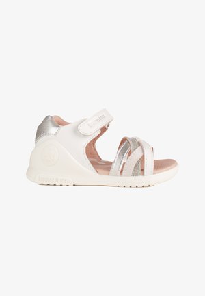 Sandalo bianco e argento per bambino con cinturino regolabile, punta aperta, soletta imbottita e suola flessibile progettati per comfort e supporto.