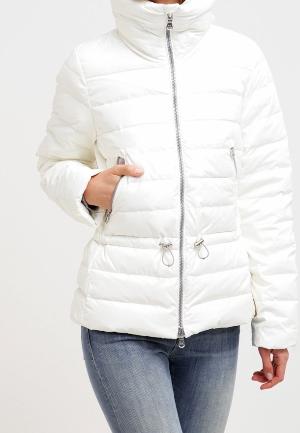 Bílá péřová bunda s vysokým límcem, předním zipem, dvěma předními kapsami a horizontálním prošíváním. Obsahuje stříbrné kovové prvky a akcenty se šňůrkami.