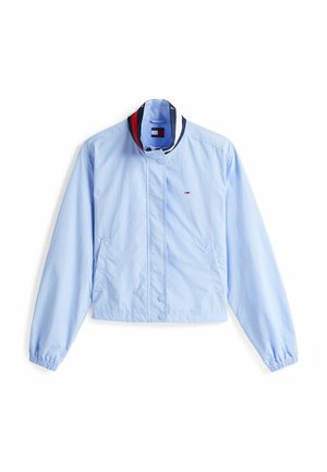 Giacca cropped azzurro chiaro realizzata in tessuto liscio. Presenta un colletto alla coreana con strisce navy e rosse, bottoni a pressione e tasche laterali.