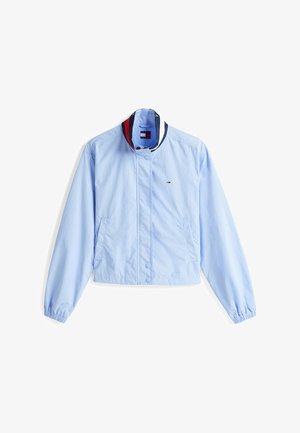 Lichtblauwe cropped jas gemaakt van gladde stof. Kenmerkt zich door een opstaande kraag met marineblauwe en rode strepen, drukknoopsluiting en zijzakken.