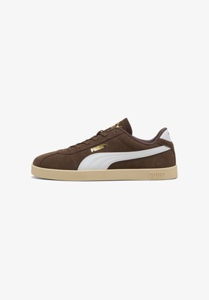 Baskets en suède marron avec des accents blancs, présentant un design texturé, un bout arrondi, une semelle en caoutchouc plate et des détails de logo PUMA en doré.