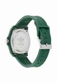 Montre en silicone verte avec un cadran octogonal, dos en acier inoxydable, bracelet texturé et quincaillerie argentée arborant le logo Adidas.