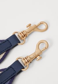 Cintura blu navy con hardware dorato, caratterizzata da due ganci girevoli con molle a spirale, accentuata da rifiniture in pelle e una texture intrecciata.