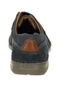 Dunkelgrauer Wildlederschuh mit einem braunen Lederakzent an der Ferse, ausgestattet mit Nähdetails und einem gepolsterten Sohlen-Design.