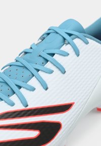Scarpa da calcio con una tomaia bianca testurizzata, lacci azzurri chiari e un logo nero accentuato da dettagli rossi. Presenta un design perforato.