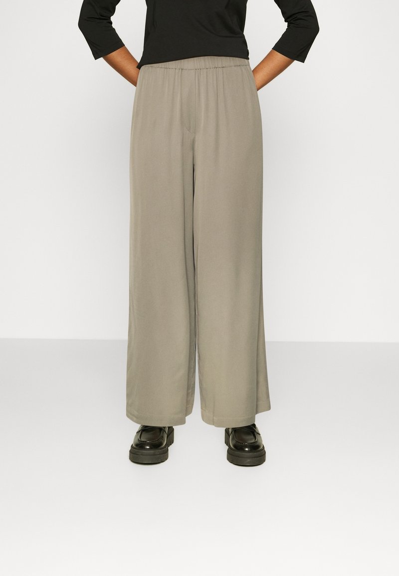 Light gray wide-leg pants with an elastic waistband, made from soft fabric, paired with black platform shoes.