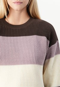 Pletený svetr s kulatým výstřihem, s vodorovnými pruhy v hnědé, světle růžové a krémové barvě; strukturovaná tkanina s volným střihem.