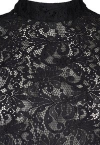 Tissu en dentelle noire à col montant avec des motifs floraux et tourbillonnants complexes, présentant des détails délicats en maille transparente.