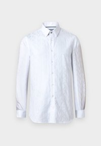 Λευκό πουκάμισο με μακριά μανίκια και κουμπιά, με διακριτικό σχέδιο ζιγκ-ζαγκ, μυτερό γιακά και μανσέτες, σε ουδέτερο γκρι φόντο.