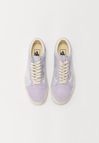 Paire de baskets basses lavande et blanches avec lacets, vue de dessus sur fond blanc.