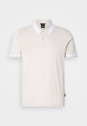 Camisa polo beige con una tapeta de dos botones, cuello a rayas blancas y acentos de mangas a juego. Fabricada en tejido liso y ligero.