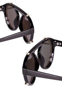 Black sunglasses with dark lenses and a glossy finish. Features gold accents and a unique, oversized silhouette. Dual frame design visible.