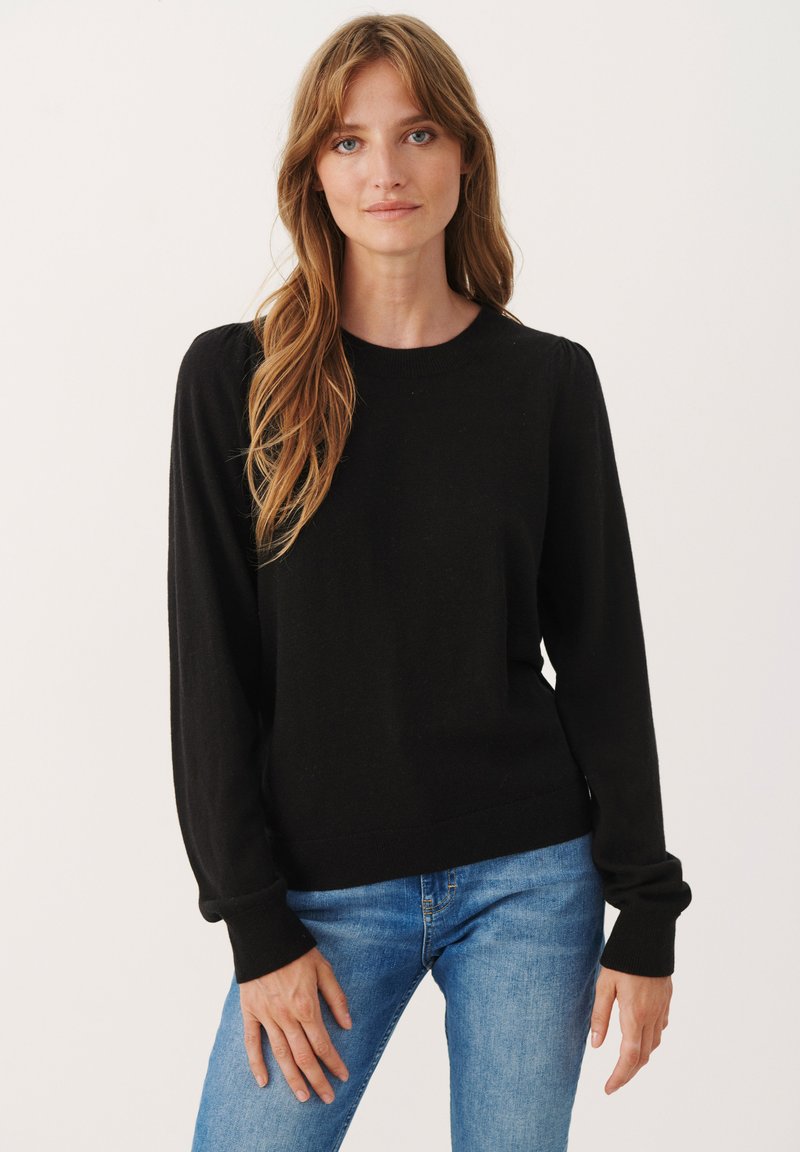 Sort, langærmet sweater med rund hals og ribbede manchetter, der har en tætsiddende stil og blød strikket tekstur. Bæres med blå jeans.