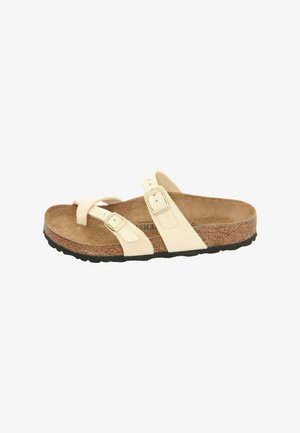 Two-strap sandal in cream leather with adjustable buckles, cork footbed, and black rubber outsole. Smooth texture and minimalistic design.