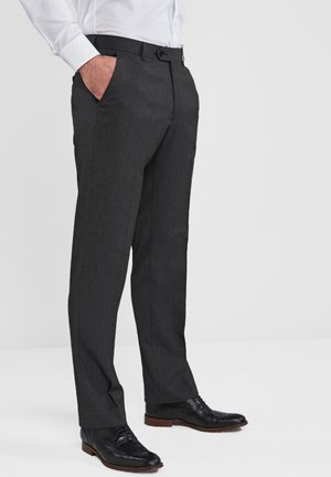 Charcoal gray dress pants with a slim fit, flat front, and side pockets. Worn with black leather shoes and a white button-up shirt.